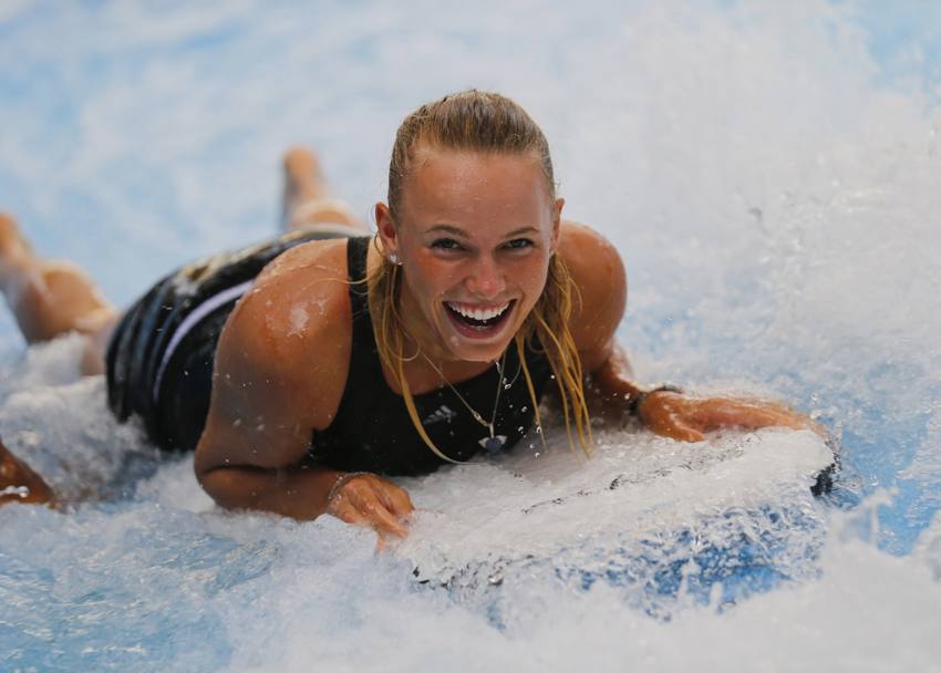 La tennista Caroline Wozniacki prova a fare surf nella piscina con onde artificiali di Dubai. (Reuters)